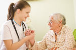 A young doctor nurse visiting an elderly sick woman...